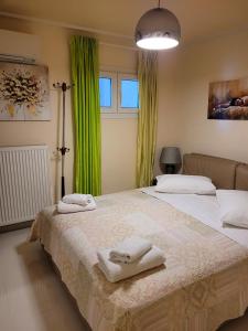 阿吉奥斯伊欧尼斯Centaur Villa的配有绿窗帘和毛巾的客房内的两张床