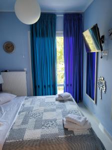 阿吉奥斯伊欧尼斯Centaur Villa的一间卧室配有一张蓝色墙壁的床和一扇窗户