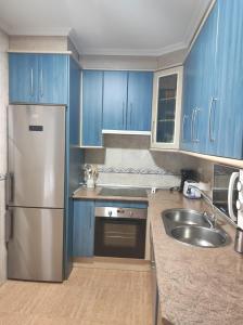 SotoserranoCasa Carla的厨房配有蓝色橱柜和不锈钢冰箱