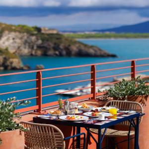 波尔图·埃尔科莱La Roqqa的阳台上的餐桌和食物,享有海景