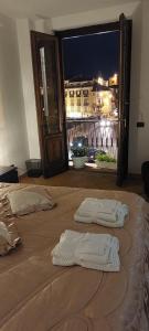 科森扎Casa Santa Lucia的床上的2条白色毛巾,享有城市美景