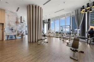 好莱坞High Floor Corner 2 BDR in Hyde Resort的大型客房设有带许多窗户的健身房