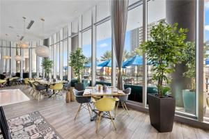 好莱坞High Floor Corner 2 BDR in Hyde Resort的餐厅设有桌椅和窗户。