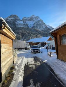 GsteigChalet at Ski Lift (Gsteig b. Gstaad)的停车场内有雪覆盖的山