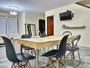 里奥内格罗HOSTAL - Casa Rionegro -10 min del aeropuerto的一间带木桌和椅子的用餐室