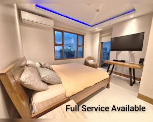 马尼拉Manila BayView Rental- Luxury 1,2,3,4 BR Condos with BALCONY POOL BAYVIEW - FULL SERVICE AVAILABLE的一间卧室设有一张大床和一台平面电视。