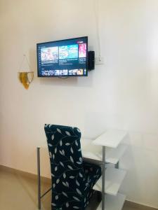普拉亚卡门Casa Ohana By Utopia的一间带椅子和墙上电视的房间