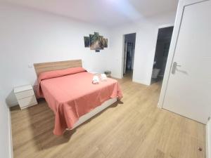 巴尔韦尔德Vivienda El Viajero的一间卧室配有一张带粉色毯子的床,铺有木地板