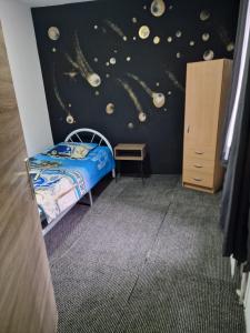 布鲁塞尔Central home的一间卧室,卧室配有床,墙上则设有行星
