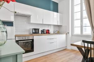 马赛La Loge Vieux-Port的厨房配有白色橱柜和炉灶烤箱。