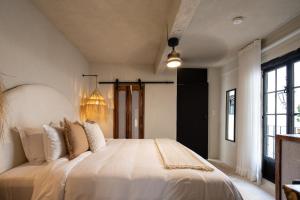 圣米格尔-德阿连德HOLT Hotel del Pueblito的卧室配有一张带白色床单和枕头的大床。