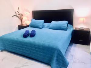 普拉亚卡门Casa Ohana By Utopia的一间卧室配有一张带蓝色床单和蓝色枕头的床。