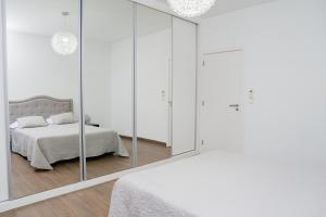普拉亚Villa Santiago的白色卧室配有床和镜子