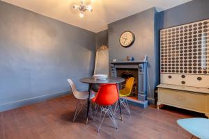 伦敦Trendy 2BD House 5 Mins from Willesden Junction!的配有桌椅和时钟的房间