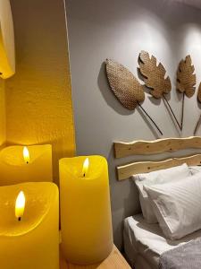 SíndosTiny Nest Sindos的卧室里放着两把黄色蜡烛,卧室里设有一张床