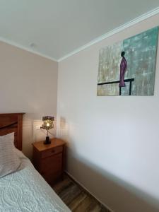 卡尔德拉Cafetto Hostal的卧室配有一张床,墙上挂着一幅画