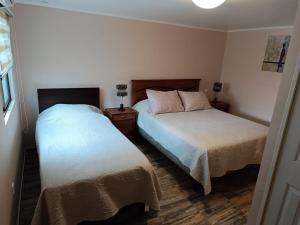 卡尔德拉Cafetto Hostal的一间卧室设有两张床和窗户。
