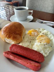 莫约班巴Murano Hotel的鸡蛋和香肠盘子,百吉饼和咖啡