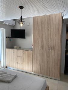 帕尔加Home Apartments的一间卧室设有大型木制橱柜,配有电视