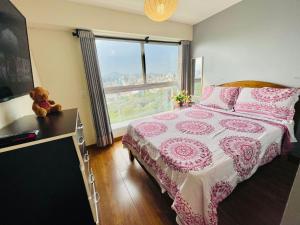 利马Habitaciones privadas con vista al parque castilla的卧室配有一张带泰迪熊的床,毗邻窗户
