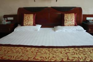 台州台山商务宾馆的一张大床,上面有两个枕头