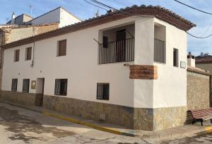 San AgustínCasa Rural El Aljibe的前面有长凳的白色建筑