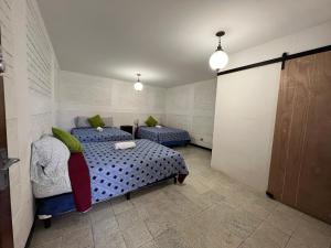 危地马拉Casa Xibalba的一间卧室设有两张床,卧室内有一扇门
