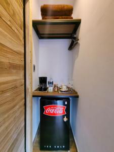 萨兰托Habitacion Deluxe 2 con Jacuzzi a 20 mt del parque的一间有柜台的房间里的古柯可乐冰箱