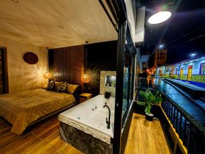 萨兰托Habitacion Deluxe 2 con Jacuzzi a 20 mt del parque的一间带一张床的卧室和一个位于火车旁的浴缸