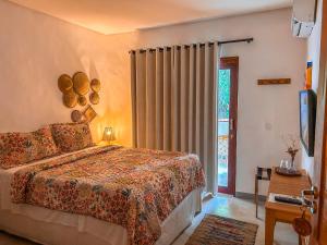 佩德拉斯港Maruê Guesthouse Porto de Pedras的一间卧室设有一张床和一个滑动玻璃门