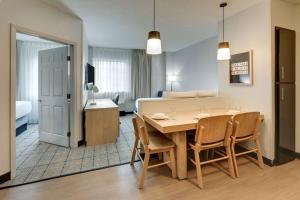 迈阿密Sonesta Simply Suites Miami Airport Doral的用餐室以及带桌椅的起居室。