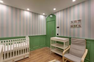 贝莱克Cullinan Belek的一个带两张婴儿床和一扇绿门的幼儿园