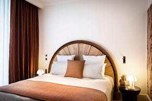 巴黎Hotel Florida Paris的一间卧室配有一张大床和木制床头板