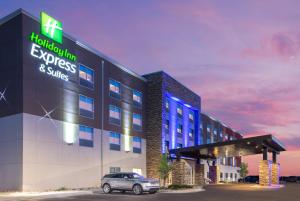 科罗拉多斯普林斯Holiday Inn Express & Suites - Colorado Springs South I-25, an IHG Hotel的前面有停车位的建筑