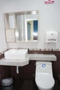 HuaquillasHotel SMIR的一间带水槽、卫生间和镜子的浴室