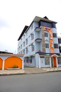 HuaquillasHotel SMIR的一座拥有橙色和白色建筑的酒店