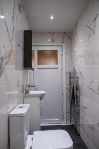 雷纳姆Lovely family home in Rainham, Kent的白色的浴室设有卫生间和水槽。