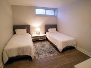 蒙特利尔Modern and spacious 2 bedroom in Montreal的小型客房 - 带2张床和窗户