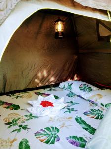 爱妮岛Bucana Beach Camp的帐篷内的一张床上,上面有花