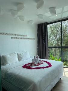 卡塔海滩Baan Saint-Tropez Seaview Villas Kata Beach的一间卧室,配有一张插花的床