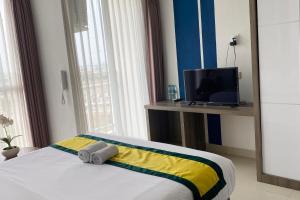 泗水Hotel Dhika Serenity Surabaya的一间酒店客房,配有一张床和一台电视