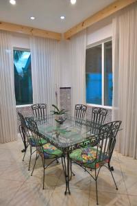 Ciudad CariariPalacio Pura Vibra的一间设有玻璃桌和椅子的用餐室