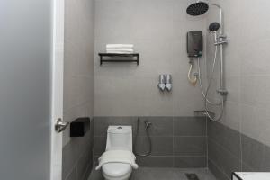 芙蓉Hotel Luma Senawang的带淋浴、卫生间和电话的浴室