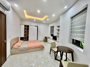 海防HPT Home II Apartment - Homestay chuỗi căn hộ Hải Phòng的一间卧室配有一张床、一张桌子和一个窗户。