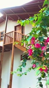 Las TunasNueva Tierra, Ayampe的一座带粉红色花卉的房屋的阳台