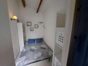 马瑟伊兰Appartement Marseillan-Plage, 2 pièces, 6 personnes - FR-1-326-798的小卧室配有带蓝色枕头的床