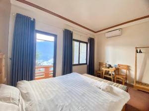 萨帕GO SAPA HOSTEL的一间卧室设有一张床和一个大窗户