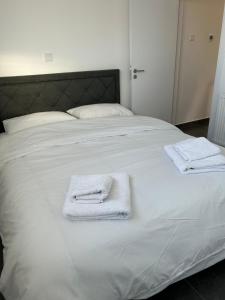 基佩朗达Arxaia skala的一张白色的床,上面有两条毛巾