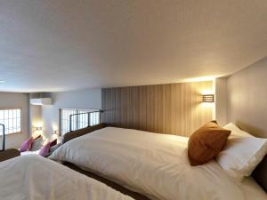 中津川市岩寿莊日式旅馆的卧室设有一张白色大床和两个窗户。