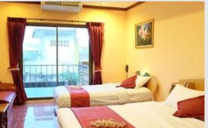 华欣the L Hua Hin的酒店客房设有两张床和窗户。